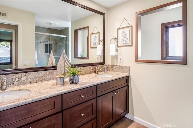 bathroom with vanity and a shower with shower door