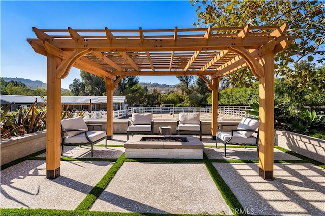 view of patio / terrace featuring a mountain view, a pergola, and an outdoor living space with a fire pit