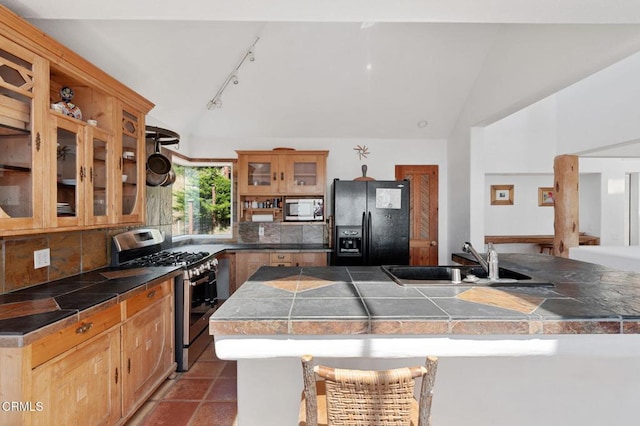 kitchen with backsplash, sink, vaulted ceiling, a kitchen island, and stainless steel appliances