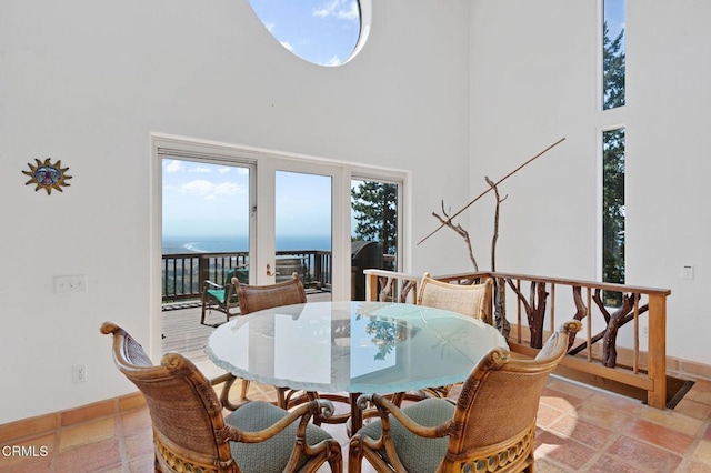 dining area with a water view and a high ceiling