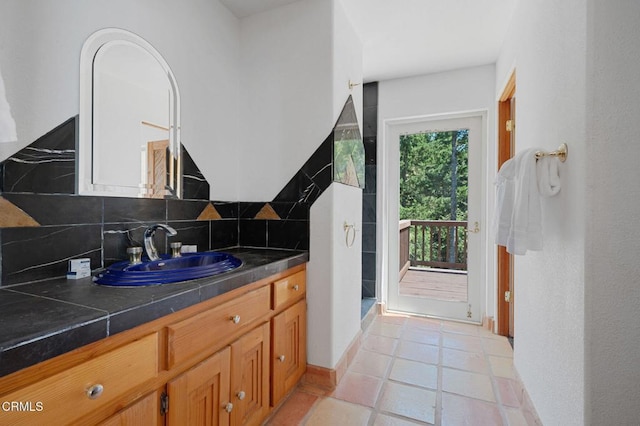 bathroom with tile patterned flooring, vanity, and backsplash