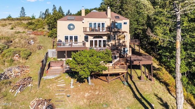 back of property with a balcony and a deck