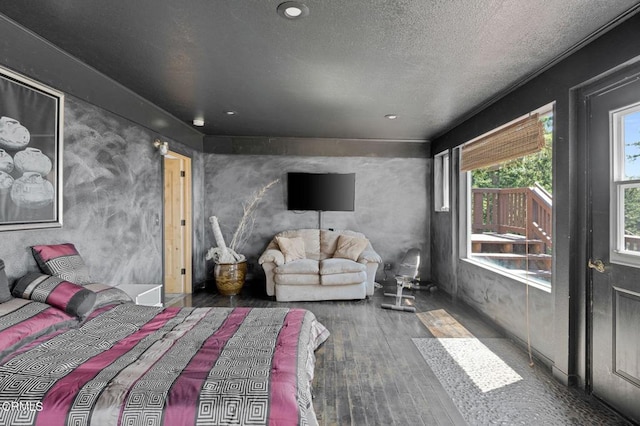 bedroom with dark hardwood / wood-style flooring and a textured ceiling