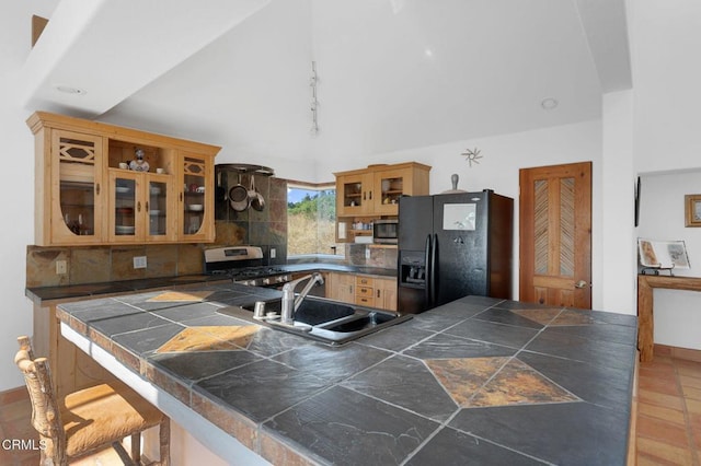 kitchen with sink, appliances with stainless steel finishes, tasteful backsplash, kitchen peninsula, and a breakfast bar area