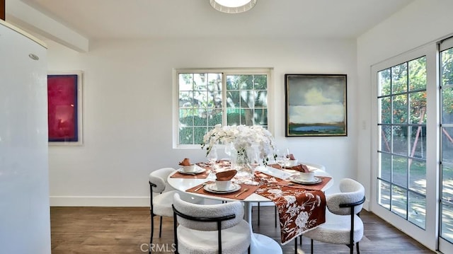 dining room featuring dark hardwood / wood-style floors and beam ceiling