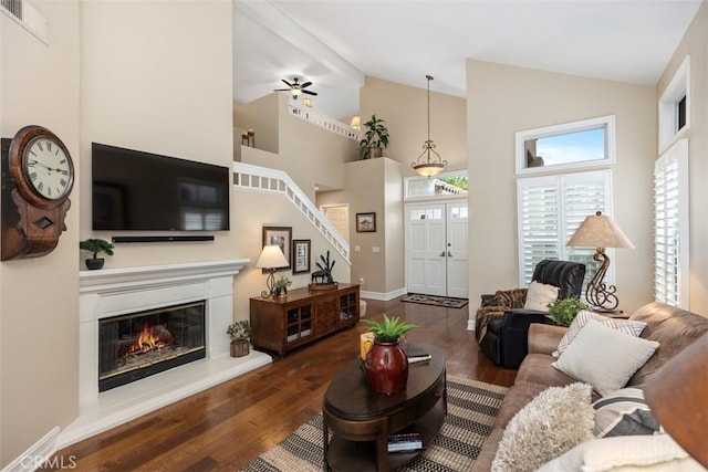 living room featuring beam ceiling, dark hardwood / wood-style flooring, high vaulted ceiling, and ceiling fan