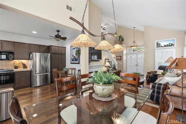 dining space with ceiling fan, lofted ceiling, and dark wood-type flooring