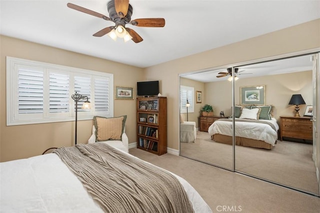 carpeted bedroom with multiple windows, ceiling fan, and a closet