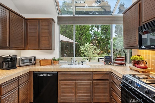 kitchen with black appliances, plenty of natural light, sink, and tile countertops