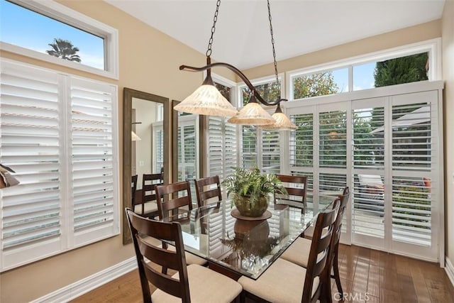 dining area featuring dark hardwood / wood-style floors, vaulted ceiling, and plenty of natural light