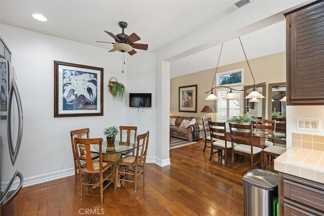 dining area featuring ceiling fan and dark wood-type flooring