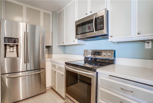 kitchen featuring white cabinets, appliances with stainless steel finishes, and a textured ceiling