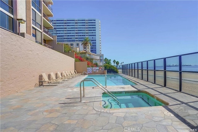 view of pool featuring a community hot tub and a water view