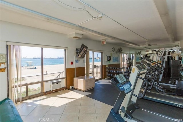 workout area featuring a wall mounted air conditioner, light tile patterned floors, and ceiling fan