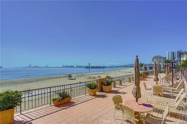 view of patio / terrace featuring a beach view and a water view