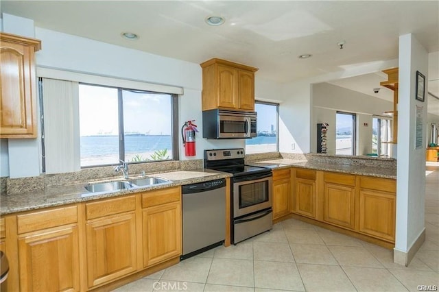 kitchen featuring a water view, stainless steel appliances, a healthy amount of sunlight, and sink