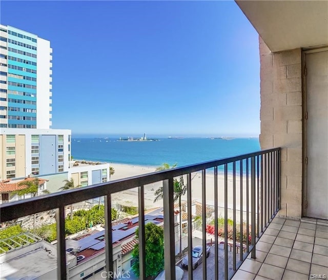 balcony featuring a view of the beach and a water view