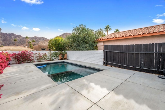 view of pool with a mountain view and a patio