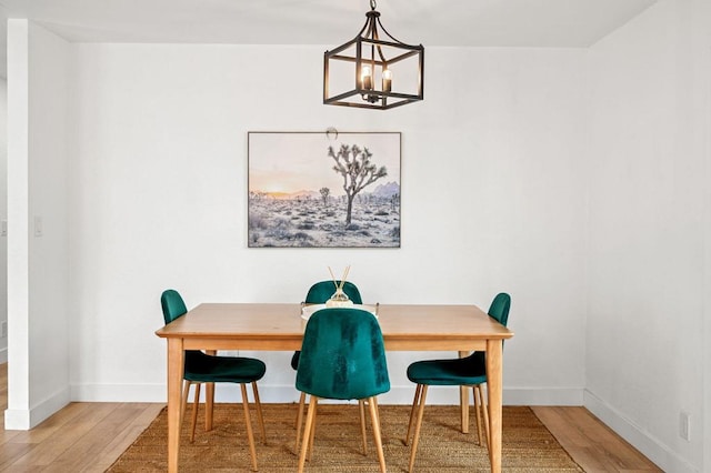 dining space with wood-type flooring and a chandelier