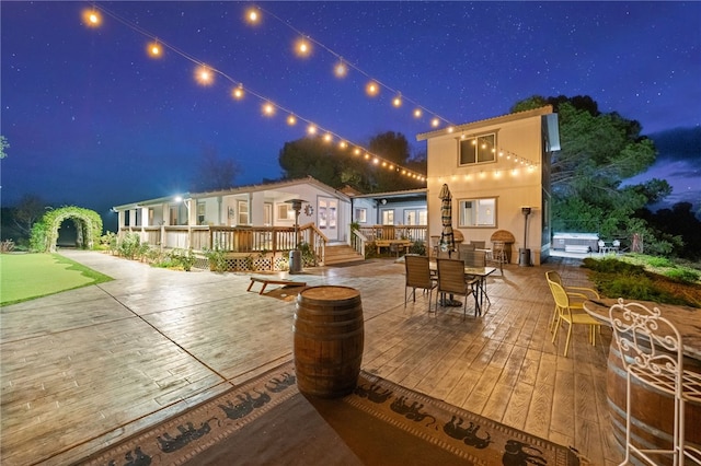 41026 Los Amantes Rd, Temecula, CA 92592 - patio at night featuring a wooden deck, a patio area, a jacuzzi, and outdoor dining area