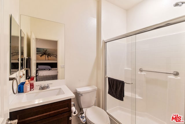 bathroom with walk in shower, vanity, and toilet