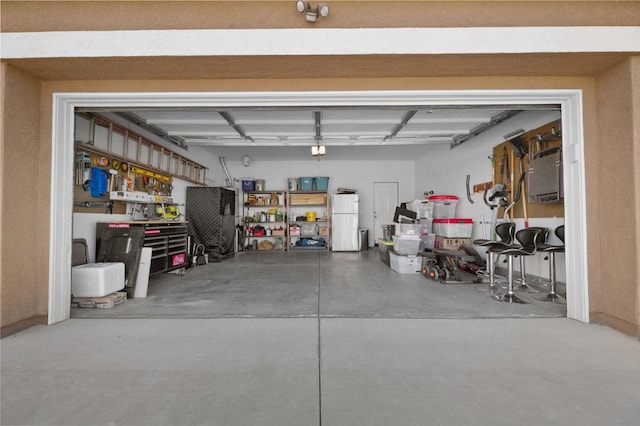 garage featuring a workshop area and white fridge