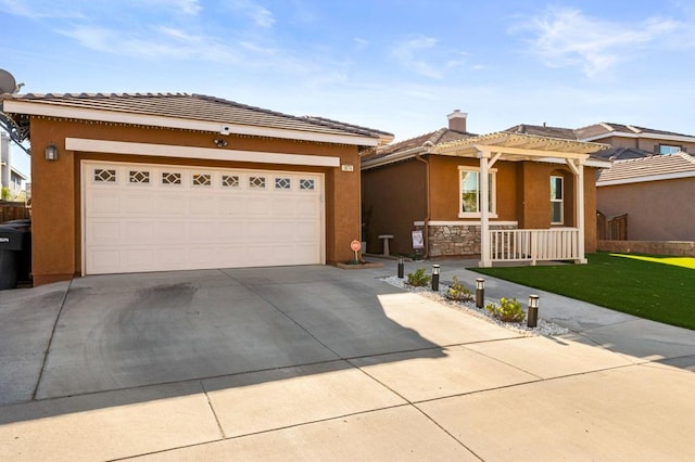 view of front of home featuring covered porch, a garage, and a front yard