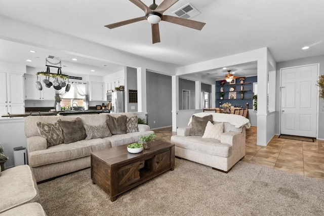 living room with ceiling fan, light tile patterned floors, and sink