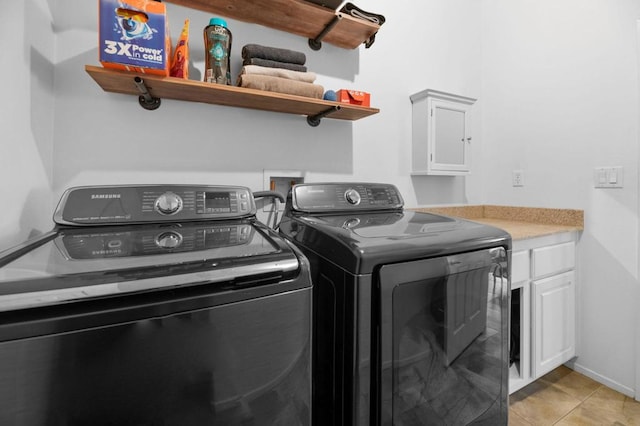 washroom featuring light tile patterned floors, cabinets, and independent washer and dryer