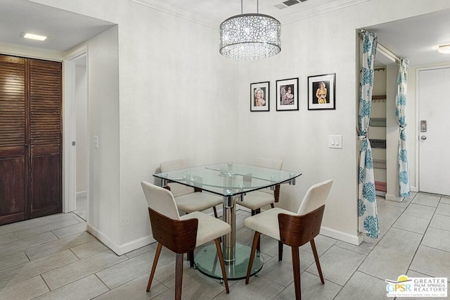 dining space with a chandelier, crown molding, and light tile patterned flooring