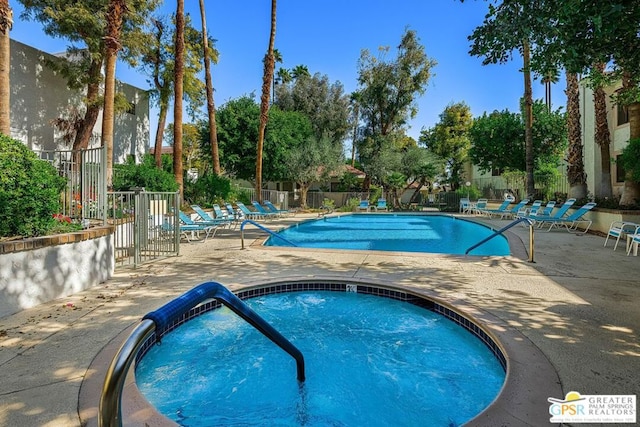 view of pool with a patio area and a hot tub