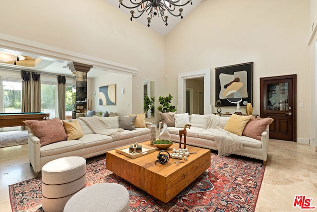 living room with a high ceiling, an inviting chandelier, and billiards