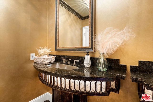 bathroom featuring ornamental molding and sink