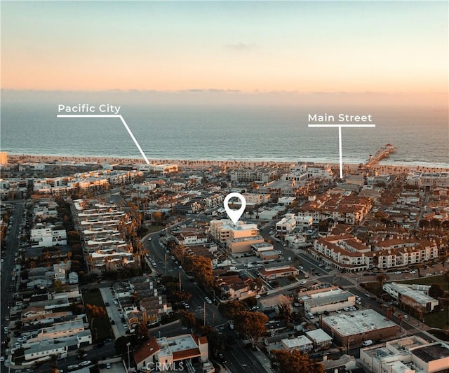 aerial view at dusk featuring a water view