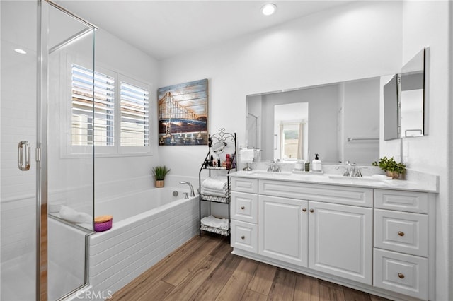 bathroom with vanity, wood-type flooring, and plus walk in shower