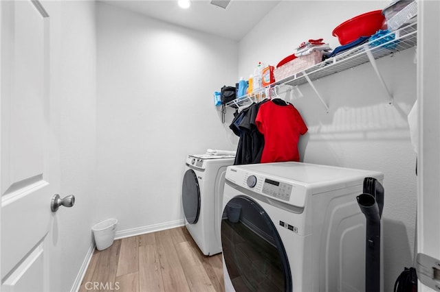 washroom with separate washer and dryer and light hardwood / wood-style flooring