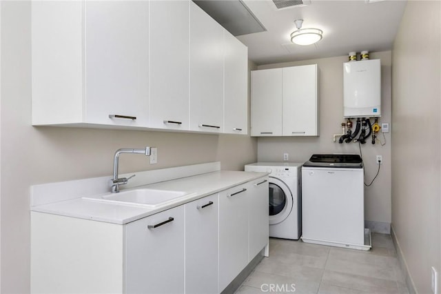 laundry area featuring sink, cabinets, tankless water heater, washer and clothes dryer, and light tile patterned floors