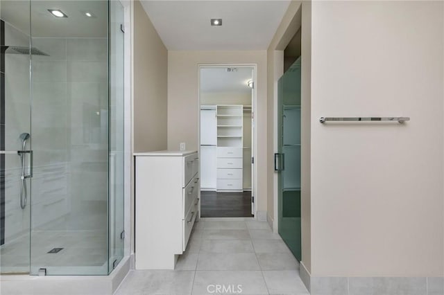 bathroom with tile patterned flooring, vanity, and walk in shower