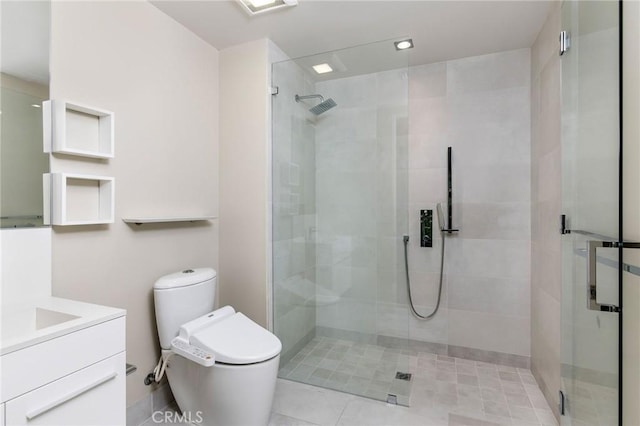 bathroom with tile patterned floors, vanity, toilet, and a shower with shower door