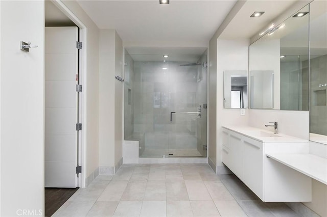 bathroom with tile patterned flooring, vanity, and a shower with door