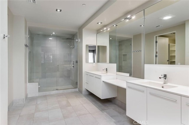 bathroom with a shower with door, vanity, and tile patterned flooring