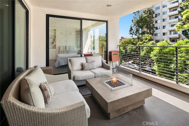 balcony with an outdoor living space with a fire pit