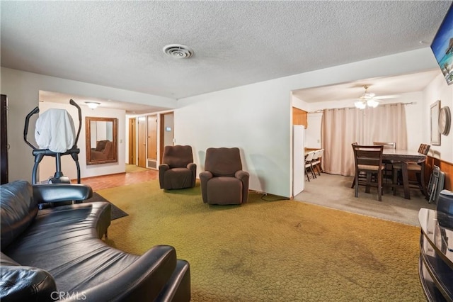 living room with ceiling fan, carpet, and a textured ceiling