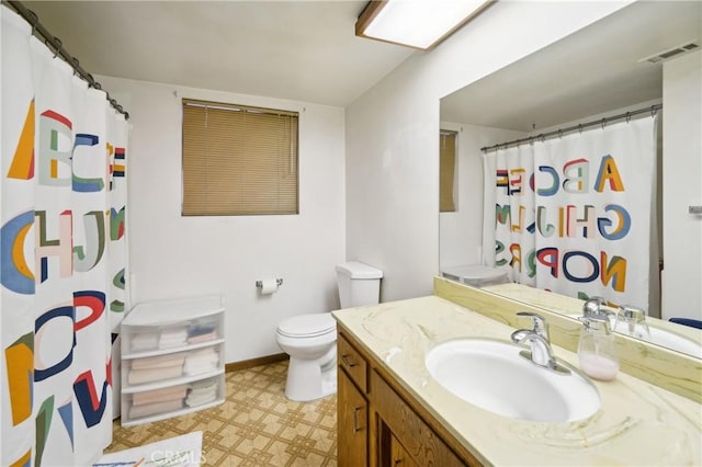 bathroom featuring curtained shower, vanity, and toilet