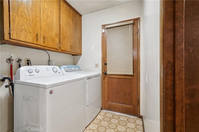 washroom with washing machine and clothes dryer and cabinets