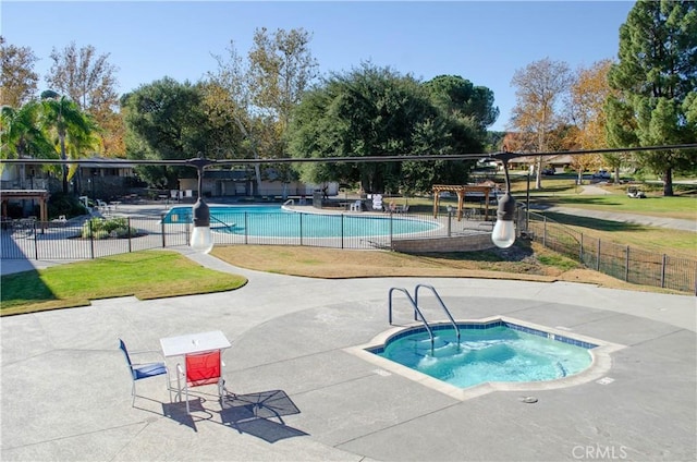 view of swimming pool featuring a hot tub and a patio