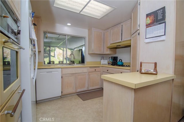 kitchen featuring light brown cabinetry, sink, kitchen peninsula, stainless steel oven, and white dishwasher