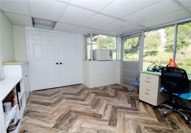 office space featuring cooling unit, dark parquet flooring, and a paneled ceiling