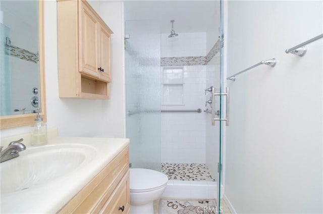 bathroom featuring tile patterned floors, toilet, walk in shower, and vanity