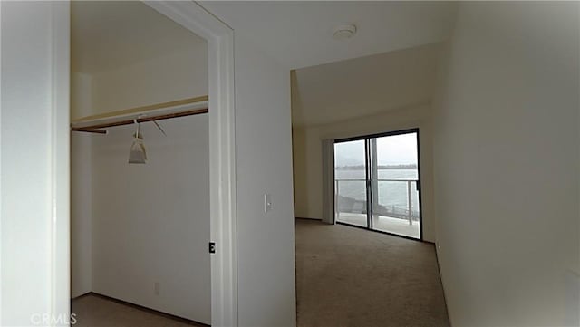 corridor with light carpet and a water view